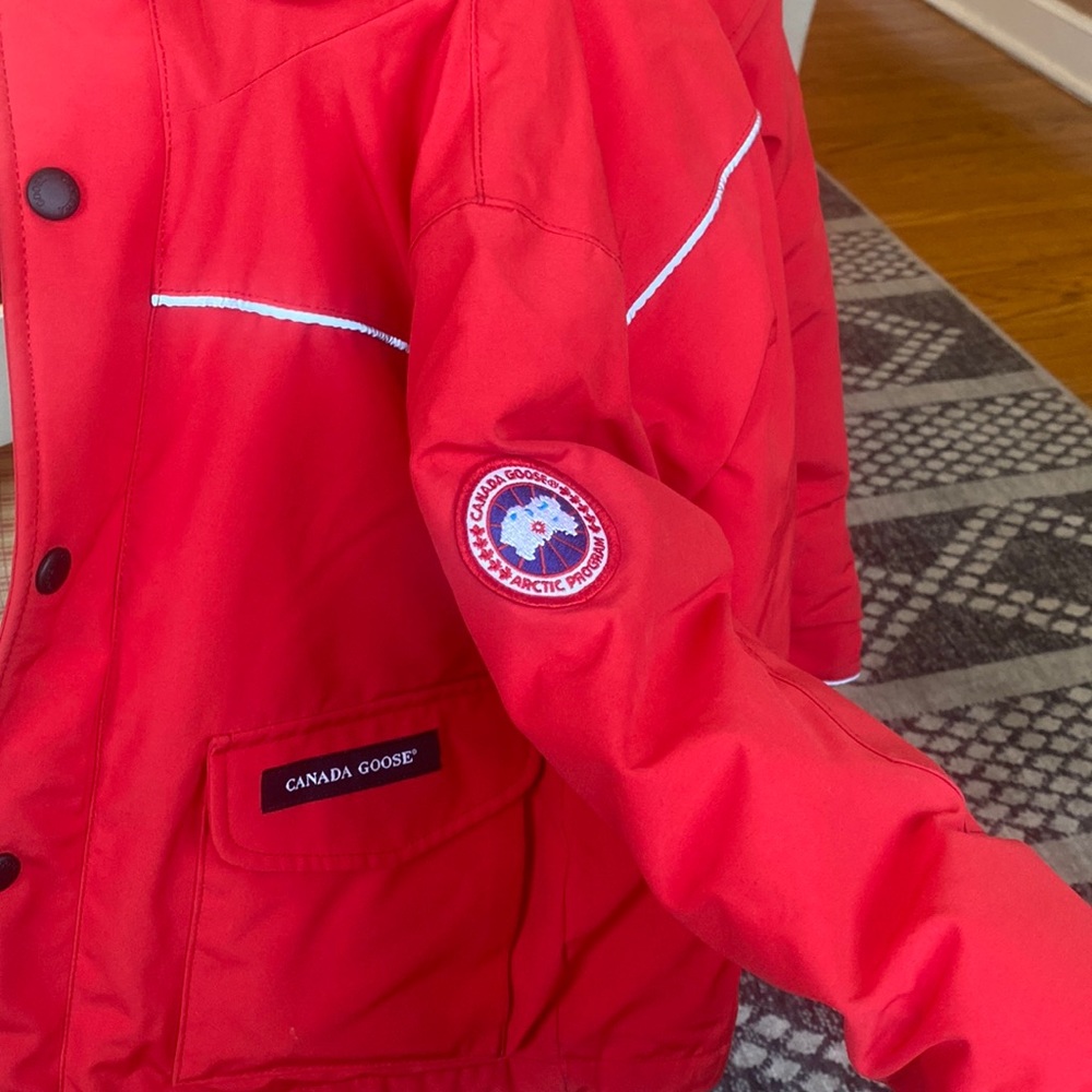 Like new RED AUTHENTIC CANADA GOOSE jacket with fur hood. Unisex. Size 4-5 yrs